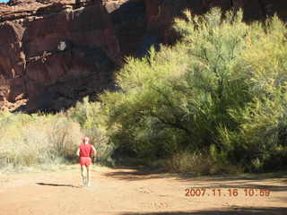 178 6bg. Canyonlands National Park - Lathrop Trail hike - Adam (tripod) running