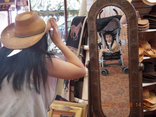 Jane trying on cowboy hat with Abigail in mirror