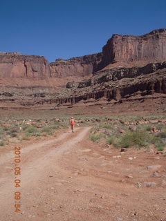 98 774. Canyonlands Lathrop Trail hike - Adam running on white rim road - back