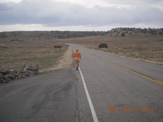 Canyonlands Lathrop hike/run - Adam running with sign