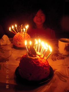 Cecelia and two lit-candle cakes