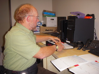 Adam signing the front of a paycheque