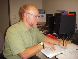 Adam signing the front of a paycheque