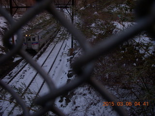 train on snowy tracks seen through the fence