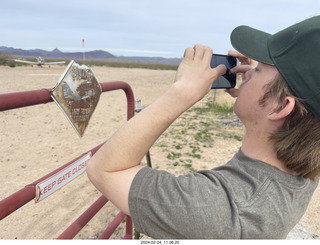 Alamo Lake - sign Caution low-flying aircraft - Tyler taking a picture